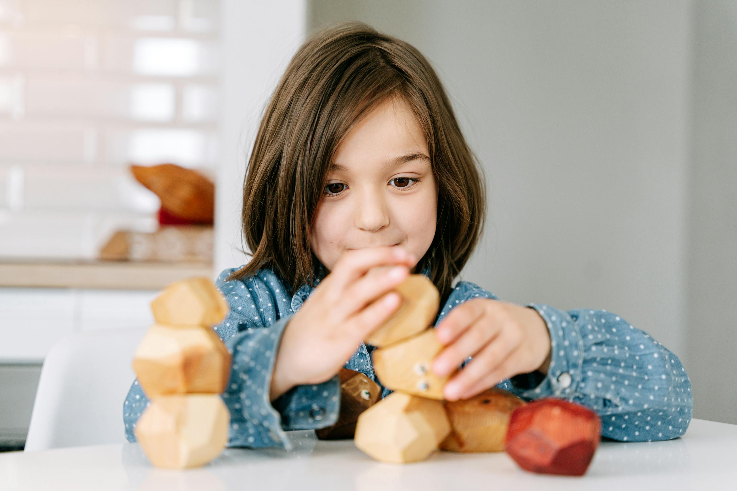 Child playing with wooden blocks, representing growth, development, and supportive therapeutic care