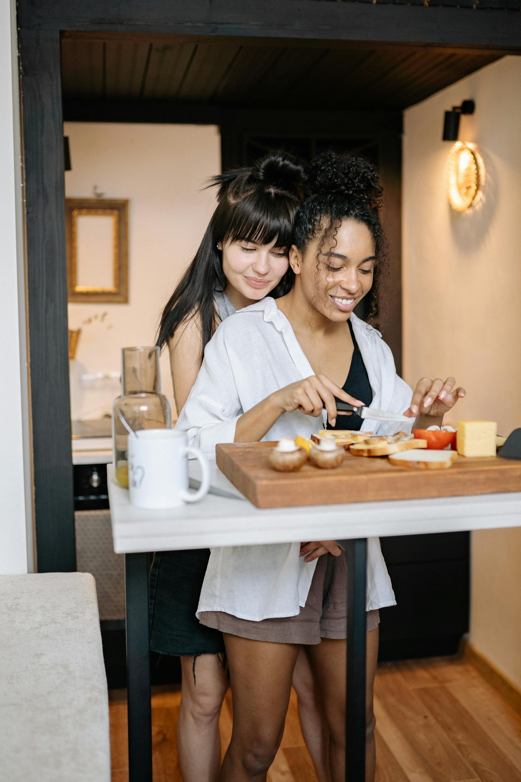 Smiling couple enjoys breakfast preparation, embracing in a cozy kitchen setting.