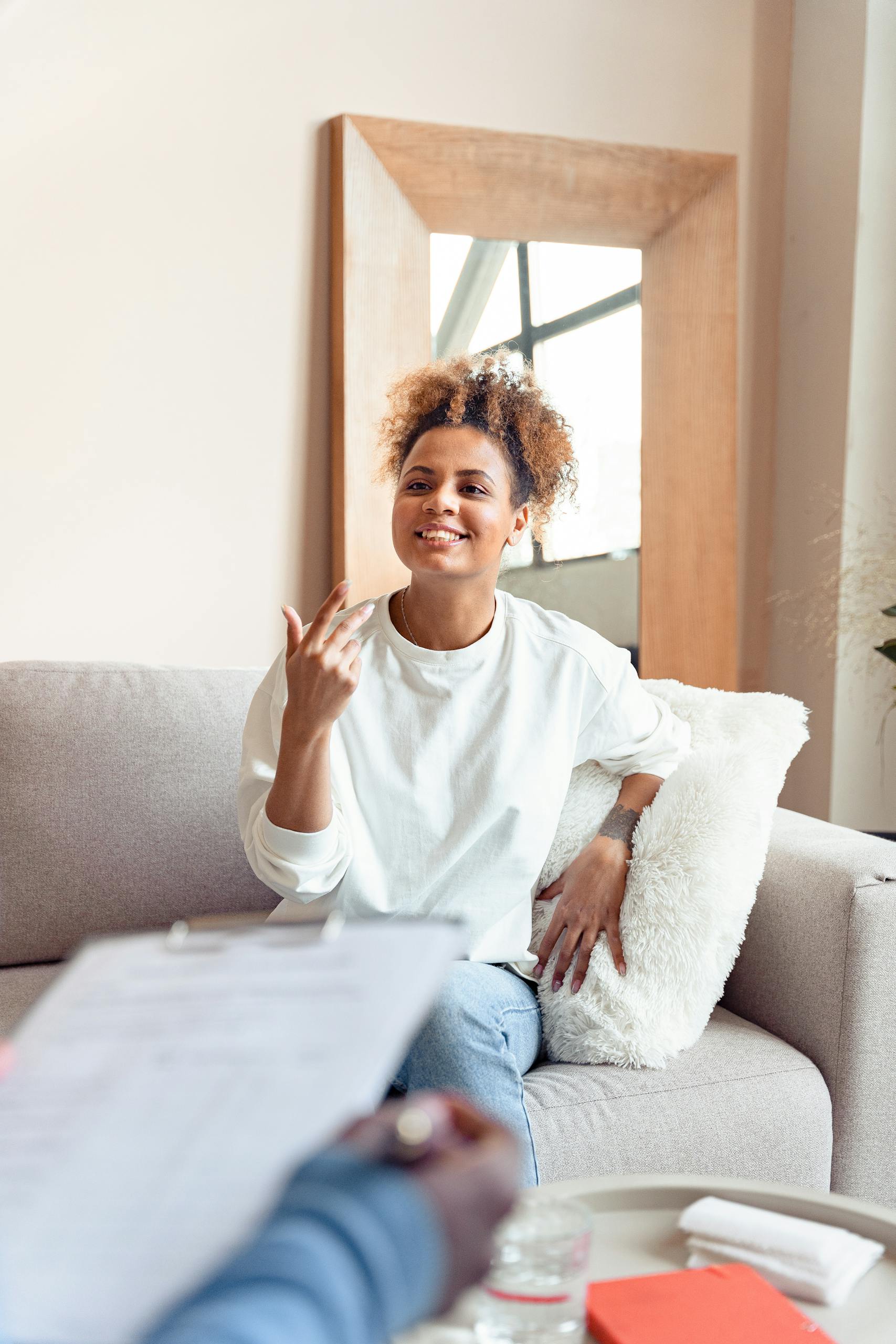 Smiling woman in a therapy session on a comfortable sofa.